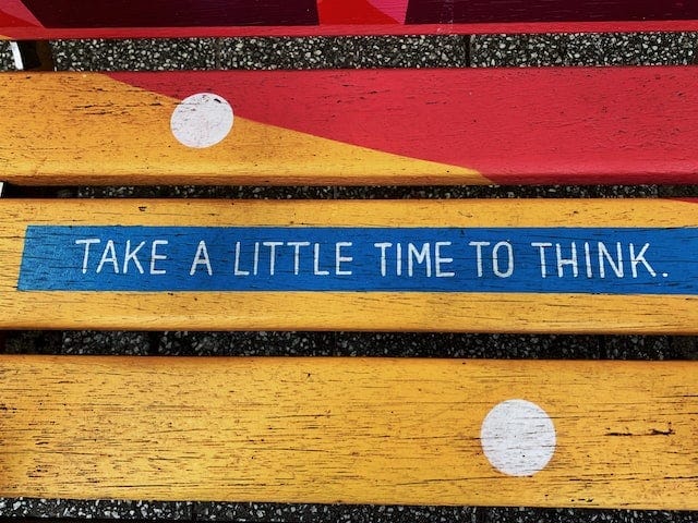 wooden bench with "take a little time to think" written on it